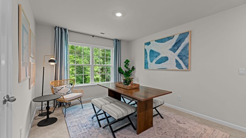 Upstairs loft area with carpet flooring and large window
