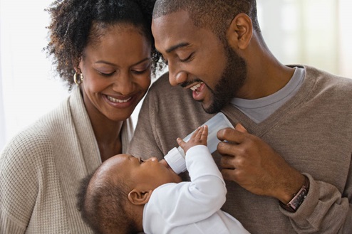 Young couple feeding baby