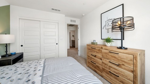 Kid's room with a bed, dresser, and window