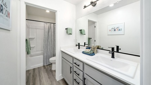 Bathroom with sinks, cabinets, shower and toilet