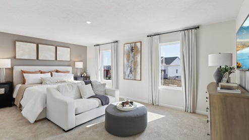 Primary suite with large windows and sitting area
