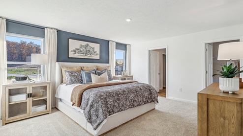 Deerfield Large primary en suite bedroom with large windows and light brown carpet