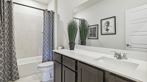 Secondary bathroom with elongated vanity and a garden tub shower