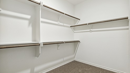 Primary walk-in closet with three hanging rods