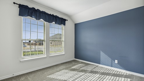 Bedroom with blue accent wall and blue curtain valence