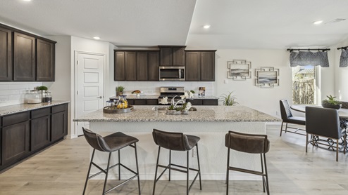 Large kitchen island with brown cabinets and large granite countertops