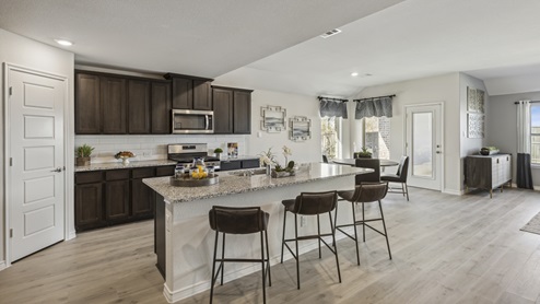 Large kitchen island with brown cabinets and large granite countertops