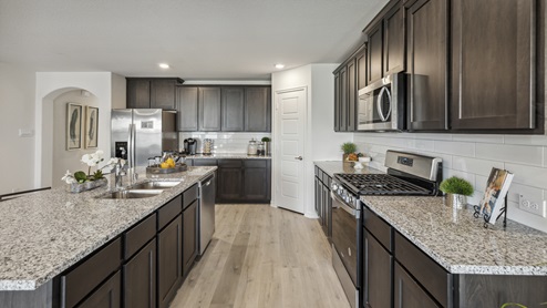 Elongated granite countertops with brown cabinets