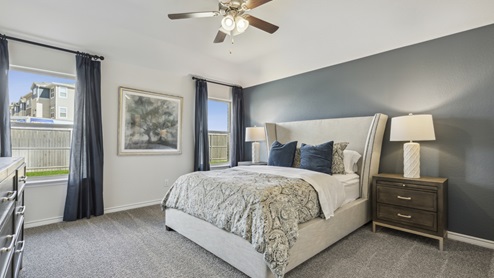 Large primary bedroom with accent wall and two windows