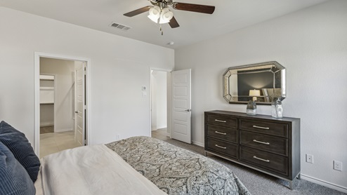 Large primary bedroom with door to living room and door to primary bathroom