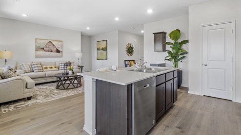 kitchen with large island and brown cabinets and views into living area