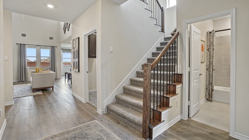 Home entry with large staircase and view into living room with window