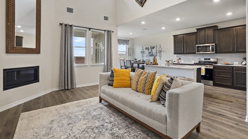 large living room with window overlooking kitchen with brown cabinets