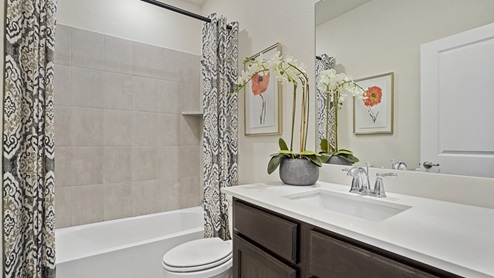 secondary bathroom with white counter vanity and tub