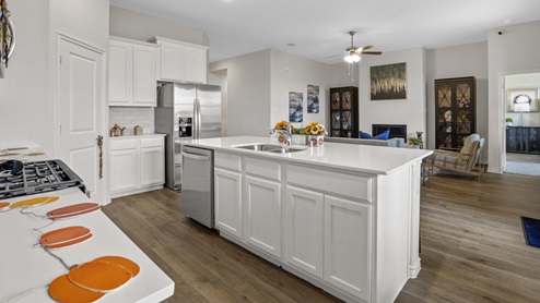 kitchen with white counters and cabinets overlooking living room