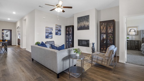 living room with couch and other furniture with ceiling fan and view into front entry
