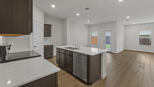 Kitchen with island next to breakfast nook and living room