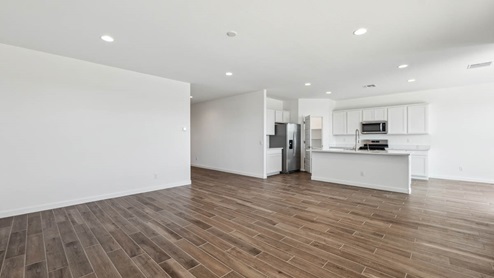 A well-organized living room that includes a kitchen and dining area, creating a warm and welcoming environment for gatherings.
