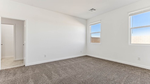 A spacious primary bedroom emphasizing open space and natural lighting.