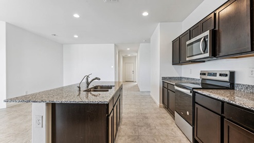 Contemporary kitchen adorned with espresso cabinets seamlessly integrated into an open dining area layout.