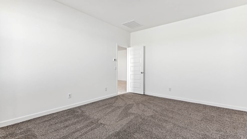 A spacious primary bedroom emphasizing open space and natural lighting.