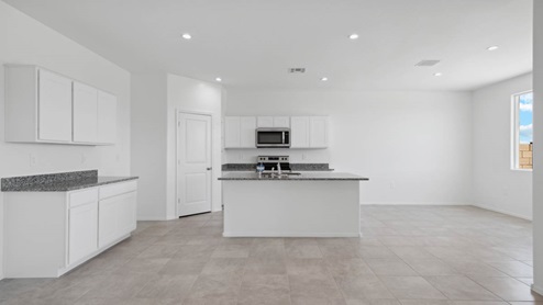 Open concept kitchen with walk-in pantry and granite countertops
