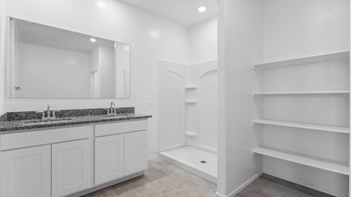 Primary bath with granite countertops and walk-in shower