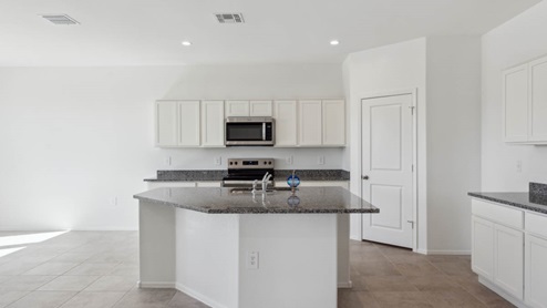 Bright and spacious kitchen with granite countertops, stainless steel appliances, and an island with bar seating.