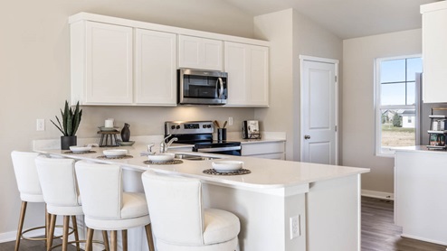 L-Shaped kitchen with white quartz countertops and a bay window