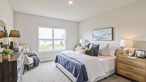large primary bedroom with large window and white bed