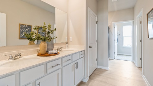 primary bathroom with large mirror and dual sinks