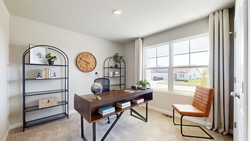 First bedroom staged as an office with desk and a chair