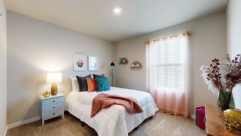 Second bedroom with white bed and overhead lighting