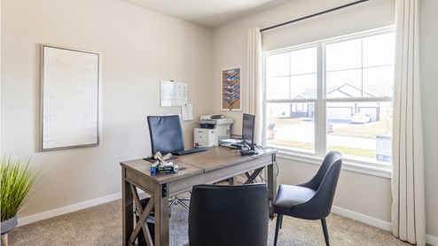 Second bedroom staged as an office with desk and chairs