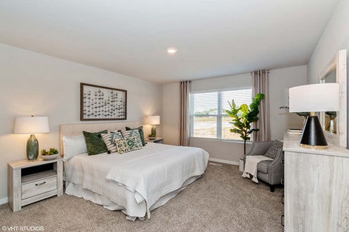 large primary bedroom with window that floods the room with natural light
