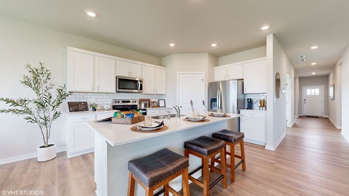 kitchen with white cabinetry and island with black barstools
