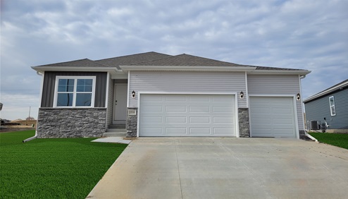 Exterior of the Roland with white and grey siding, stone and 3 car garage