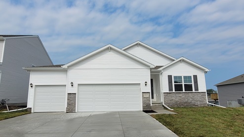 Exterior of the Hamilton with white siding, stone and 3 car garage