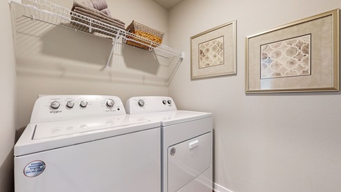 washer and dryer in laundry room with shelving
