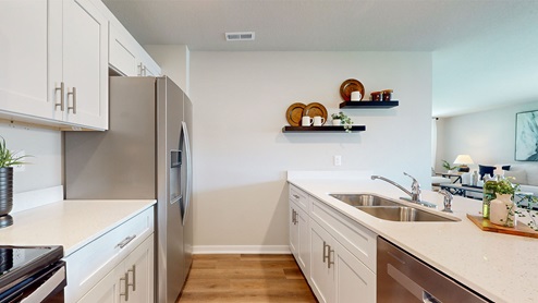 kitchen with floating shelves on wall and stainless-steel appliances