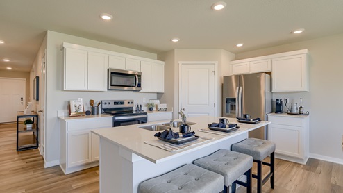 Hamilton kitchen with white cabnits stainless steel appliances and island with barstools