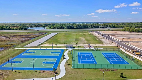 Arial show of double outdoor basketball court and double tennis court amenity.
