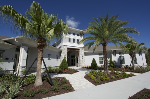 Clubhouse entrance with palm trees for amenities.