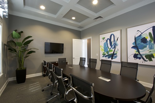 Conference room with large table and seating inside clubhouse.
