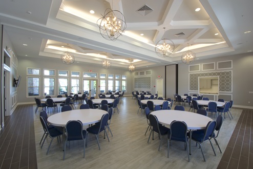Inside dining room in clubhouse showing multiple tables with seating.