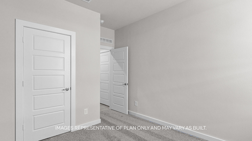 guest bedroom with plush carpet, white interior and spacious closet