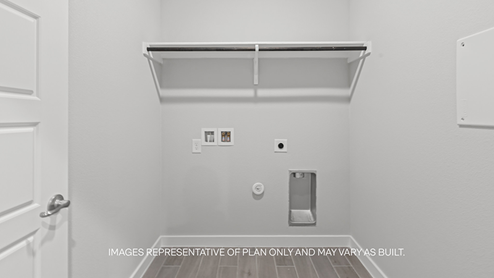 Laundry and utility room with wooden shelving just off the entry way