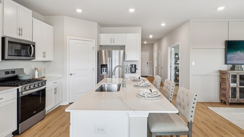 white kitchen with island and stainless-steel appliances