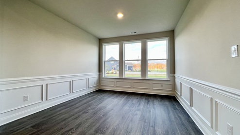 Dining room with large windows and wainscotting.