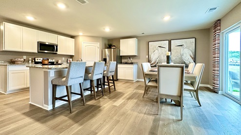 The kitchen is open to the informal dining area that leads to the back sliding door.